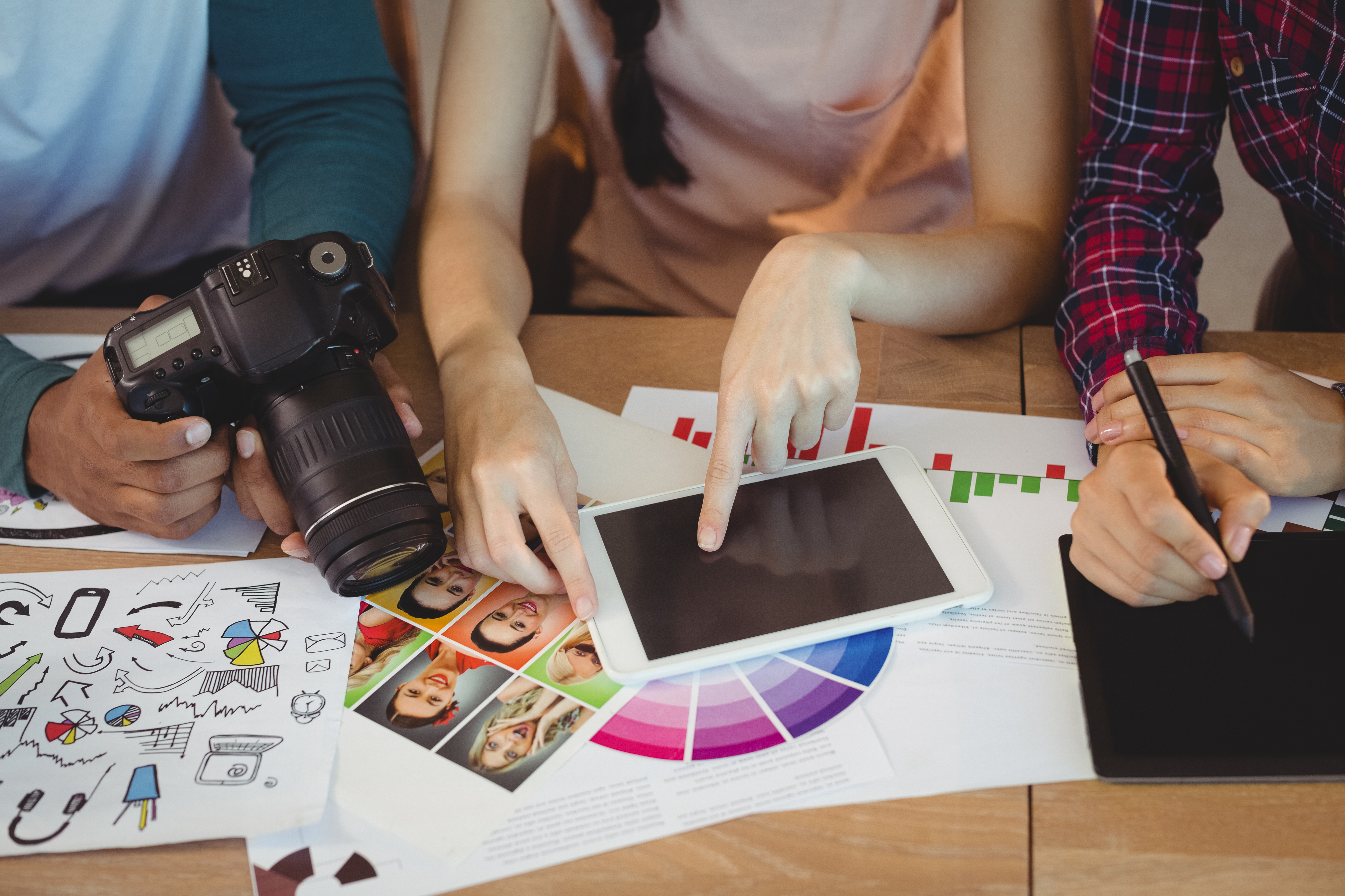 Mid section of graphic designers interacting with each other while working in office