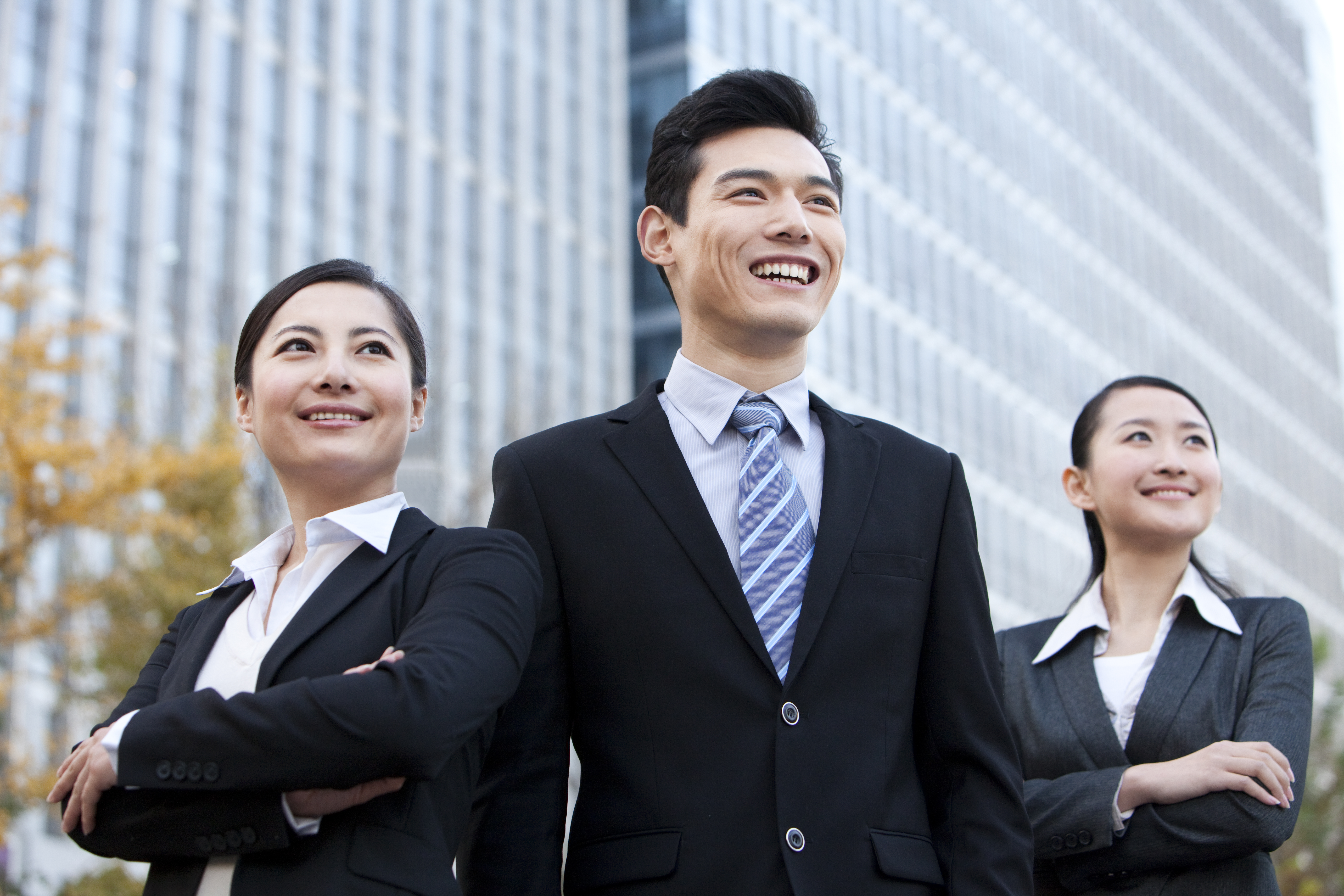 A team of Chinese businesspeople outside office buildings