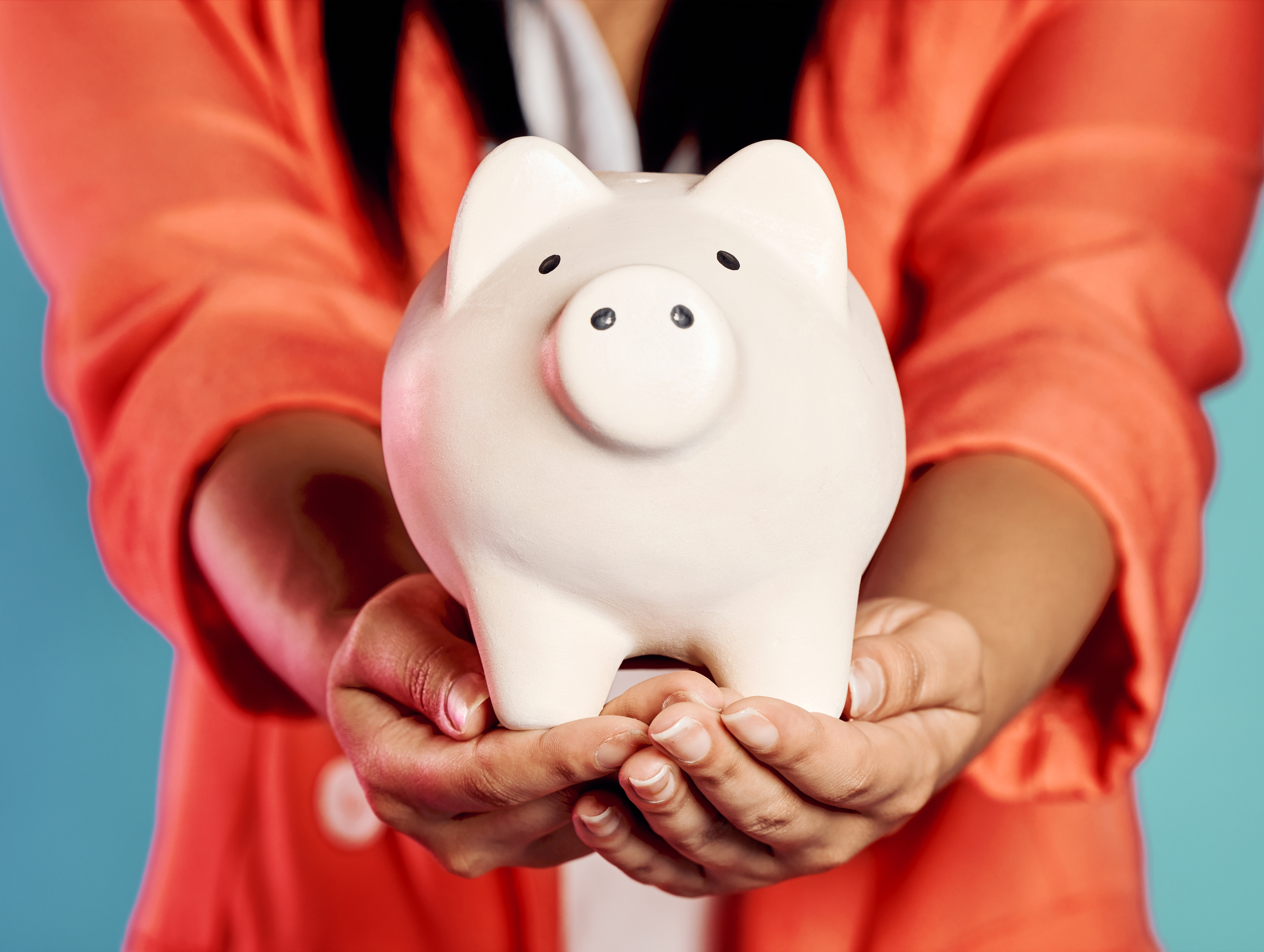 Closeup of a stylish, trendy and elegant female hands holding a piggy bank with her savings. Woman .