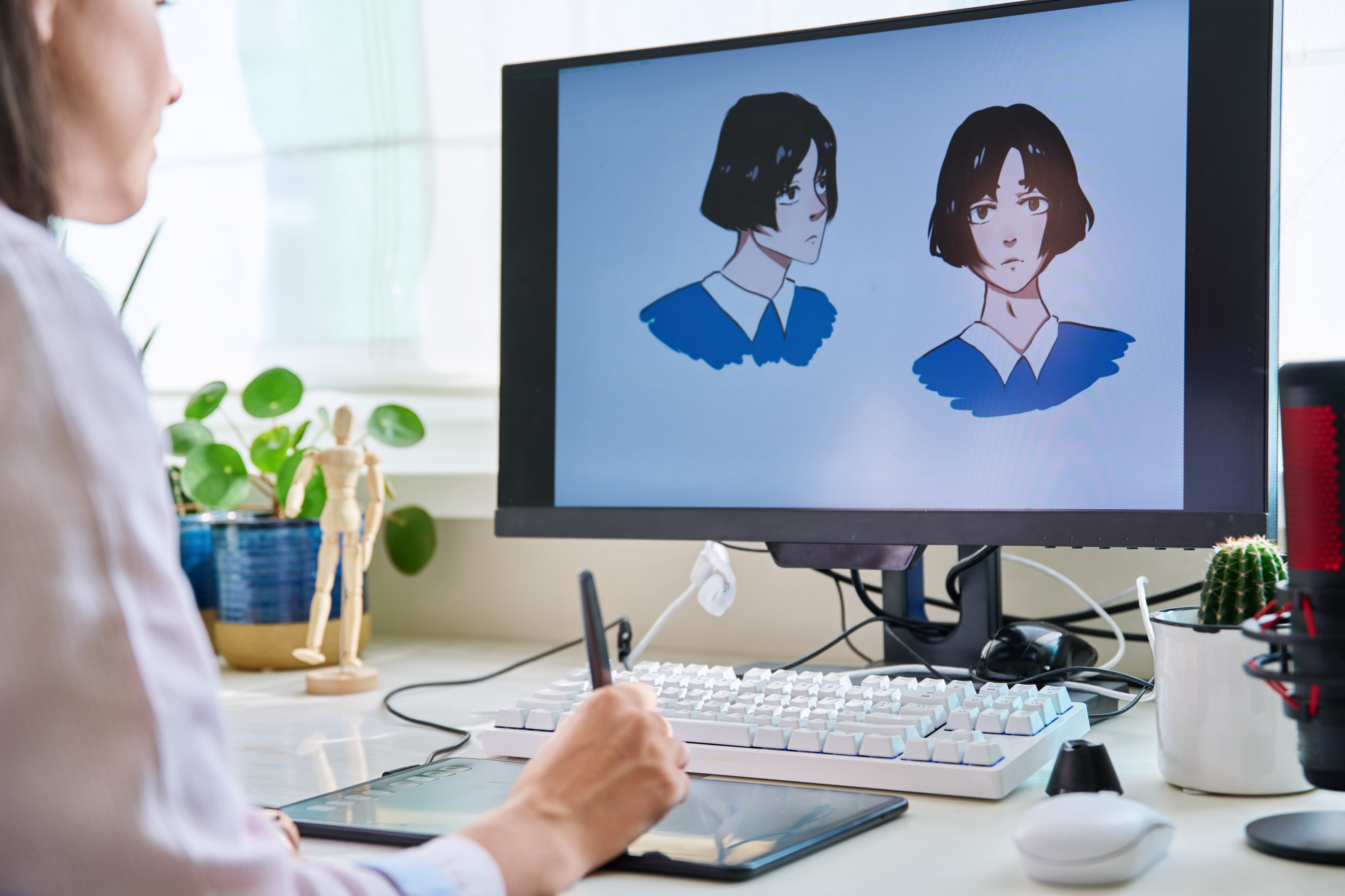 Young female graphic designer drawing sketch on graphics tablet, sitting in home office, female freelancer working remotely. Designer artist creating characters for book, anime, cartoon illustrations